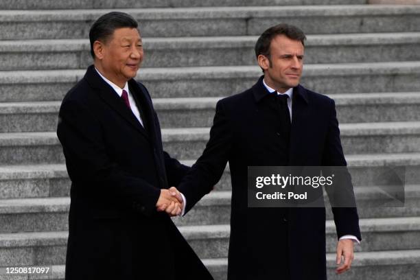 French President Emmanuel Macron shakes hands with Chinese President Xi Jinping during a welcome ceremony outside the Great Hall of the People on...