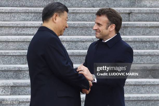 China's President Xi Jinping shakes hands with his French counterpart Emmanuel Macron as they attend the official welcoming ceremony in Beijing on...