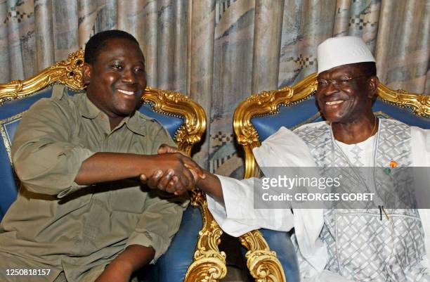 Ivory Coast's lead government negotiator, Laurent Dona Fologo, shakes hands with Guillaume Soro , MPCI's general secretary, in Lome 31 October 2002...