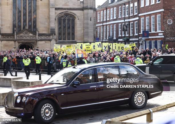 Protesters hold up banners and placards saying 'Not My King' during the arrival of the car bringing Britain's King Charles III and Britain's Camilla,...