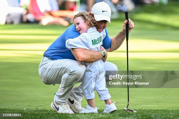 Rory McIlroy of Northern Ireland hugs his daughter Poppy on the ninth hole during the Par 3 Contest prior to the 2023 Masters Tournament at Augusta...