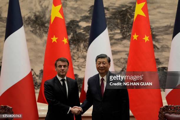 French President Emmanuel Macron shakes hands with Chinese President Xi Jinping during a joint meeting of the press at the Great Hall of the People...