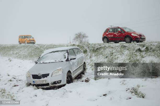 Grey-coloured car got stuck in a nearby field after it slipped off the snow-covered highway on March 30, 2023 near Kosice, Slovakia. The unexpected...