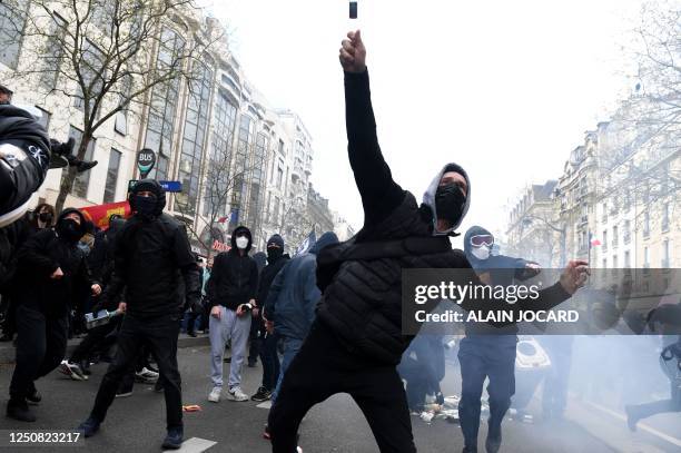 Protester throws a bottle towards riot police during a demonstration on the 11th day of action after the government pushed a pensions reform through...