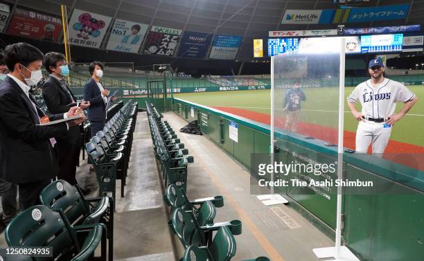 Pitcher Zach Neal of the Saitama Seibu Lions is interviewed through the transparent plastic sheet to avoid possible Covid-19 infections after the...