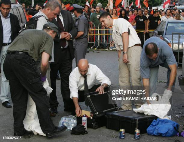 Federal Bureau of Investigation agents prepare to check the wrecked car of assassinated Lebanese journalist Samir Kassir, a columnist on the leading...