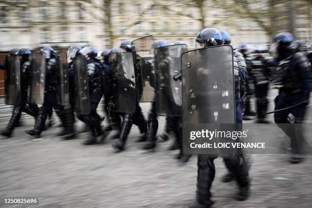 Anti-riot police hold their shields during clashes with protesters on the sidelines of a demonstration on the 11th day of action after the government...