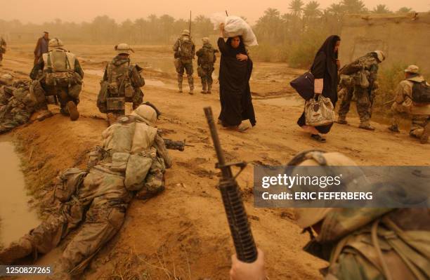 Iraqi women are evacuated by US Marines from the 2nd Battalion 8th Regiment following clashes 26 March 2003 with Iraqi forces near the southern city...