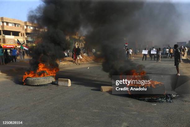 Protesters burn tires as they protest against framework agreement signed between the military and civilians, which aims to resolve the governance...