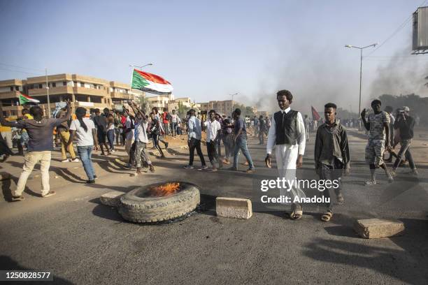 Protesters burn tires as they protest against framework agreement signed between the military and civilians, which aims to resolve the governance...