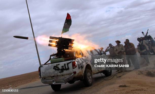 Libya's National Transitional Council fighters launch a rocket toward the desert city of Bani Walid on October 11, 2011 from an outpost on the...