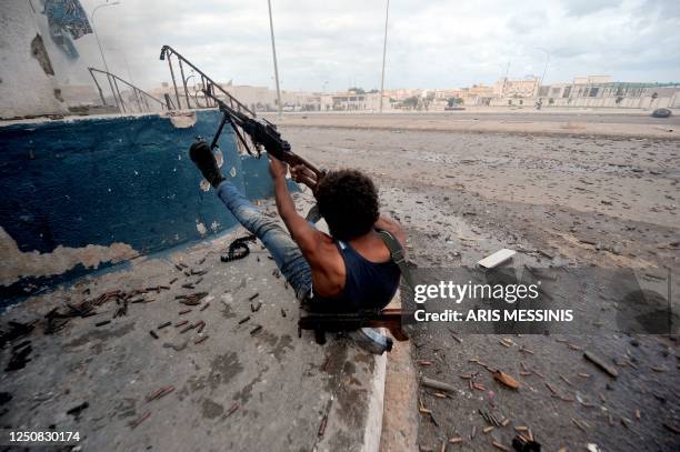 National Transitional Council fighter fires against troops loyal to Moamer Kadhafi in Sirte on October 10, 2011. Libya's new regime forces were...