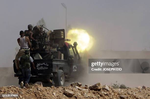 Fighters loyal to Libya's new leaders fire their artillery during clashes with pro-Kadhafi armed men in the city of Bani Walid, southeast of Tripoli...