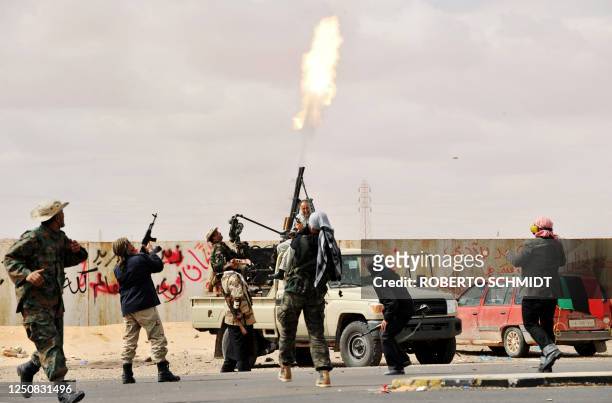 Libyan rebel fighters fire an anti-aircraft weapon at an airforce jet loyal to leader Moamer Kadhafi flying overhead during clashes few kilometers...