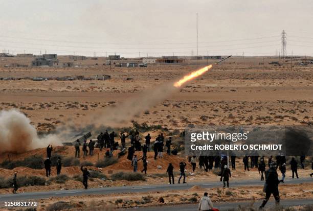Libyan rebel fighters launch a rocket towards a position held by forces loyal to leader Moamer Kadhafi during clashes between the two side few...
