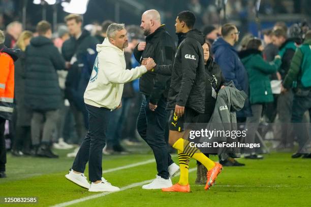Head coach Thomas Reis of FC Schalke 04 shakes hands with Sebastien Haller of Borussia Dortmund after the Bundesliga match between FC Schalke 04 and...