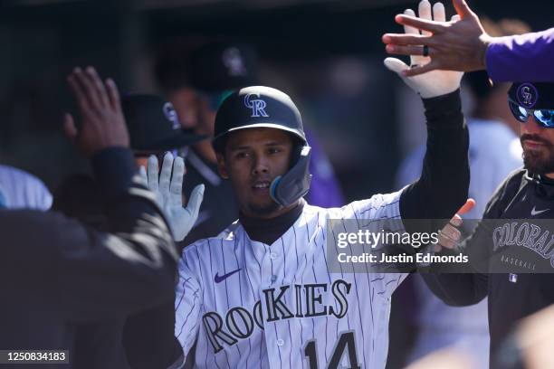 Ezequiel Tovar of the Colorado Rockies is congratulated in the dugout after scoring during the fifth inning against the Washington Nationals on...