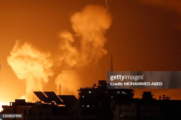 Smoke rises above buildings in Gaza City as Israel launches air strikes on the Palestinian enclave on late April 6, 2023. - Several explosions coming...