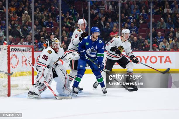 Alex Stalock Connor Murphy and Alex Vlasic of the Chicago Blackhawks defend against Elias Pettersson of the Vancouver Canucks during the first period...