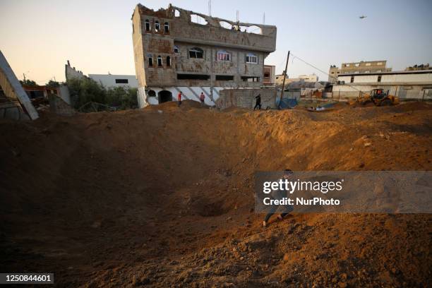 Palestinians stand next to craters left during an early morning Israeli air strike in Gaza City, on April 7, 2023. - Israel launched air strikes in...