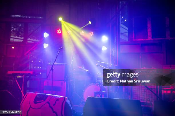 empty illuminated stage with drum kit, guitar and microphones. - festival de cine fotografías e imágenes de stock