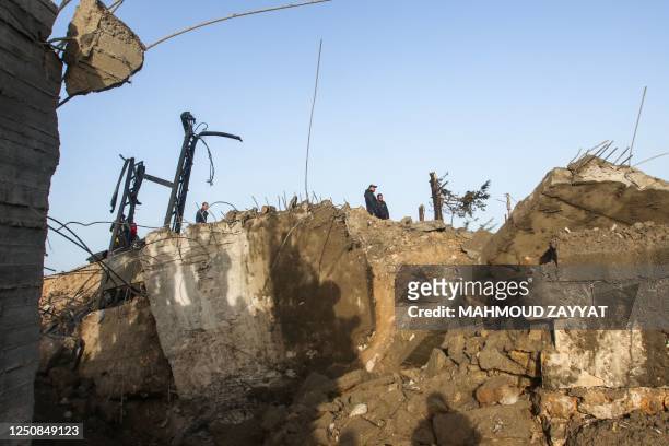 People check a damaged bridge following Israeli air strikes in the village of Qlaile, on the outskirts of Tyre, on April 7, 2023. - Israel launched...