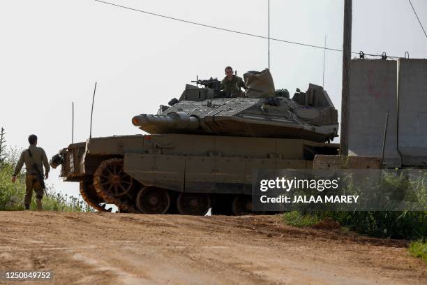 Israeli soldiers take up a position with a tank near Shtula, bordering Lebanon, on April 7, 2023. - Israel launched air strikes before dawn on April...