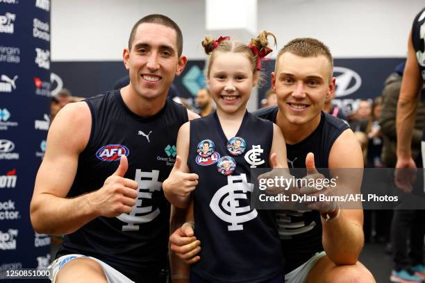 Jacob Weitering and Patrick Cripps of the Blues pose for a photo with a young fan during the 2023 AFL Round 04 match between the North Melbourne...