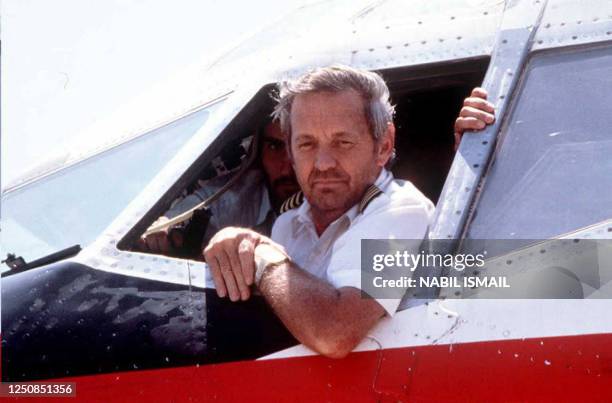 This file photo taken 19 June 1985 at the Beirut airport, in Lebanon, shows former TWA pilot John Testrake answering journalists' questions with a...