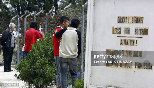Turkish Cypriots look through a fence to the Greek part of the island on referendum day, 24 April 2004 in Morphou. Turkish Cypriots are to cast their...