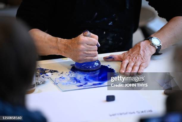 Peter Pelkmans, a lecturer at the Rijksmuseum's drawing school, smashes Lapis Lazuli blue pigment in Amsterdam on April 6 explaining how paint was...