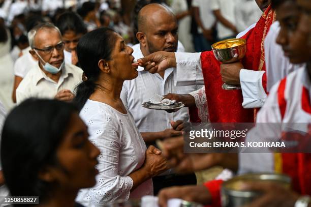 Catholic devotee receives Holy Communion during a Good Friday at St. Peter's Church in Mabima, in the suburb of Colombo on April 7, 2023.