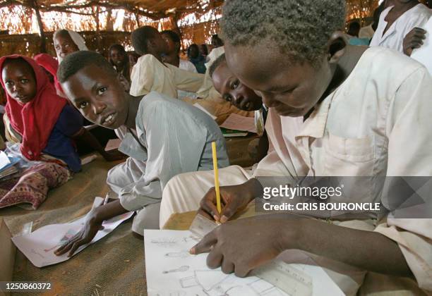 Sudanese boys and girls sit in their makeshift classroom in the new Internally Displaced camp of Krinding-2, on the outskirts of the western town of...