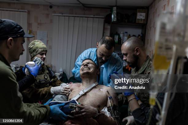 Ukrainian medics of the battalion "Da Vinci Wolves" and "Ulf" paramedical unit treat a wounded Ukrainian soldier on the Bakhmut front as...