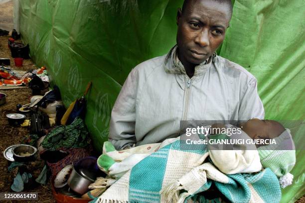 Congolese refuge holds his son, 19 June 2004, at the Rugombo refugee camp, 20 kms from the Congolese border. Almost 25,000 people have fled...