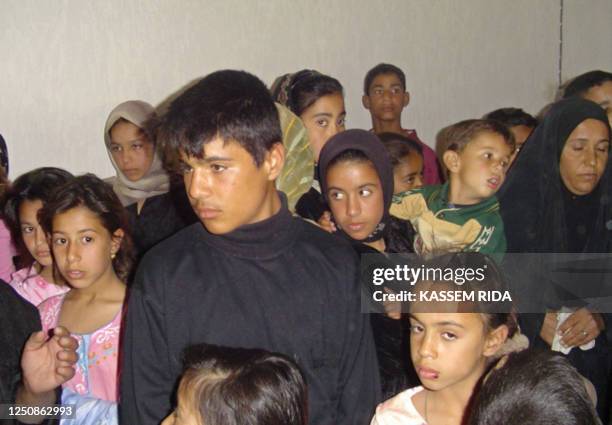 Iraqi Shiite children, who fled their homes in the Sunni town of Latifiya, take refuge in one of the unfinished houses in the city of Hilla, south of...