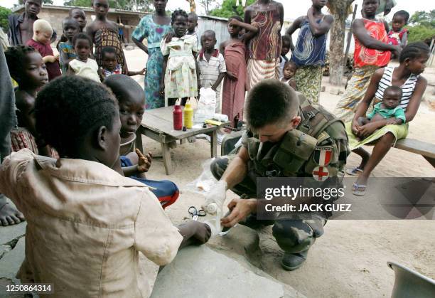 Un soldat Francais de la Force Licorne en Côte d'Ivoire soigne, le 27 octobre 2005, des habitants du village de Fitaïssou. Fitaïssou est l'un des...
