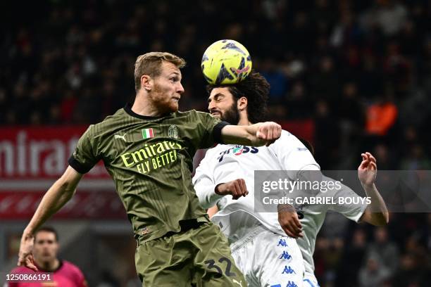 Milan's Italian midfielder Tommaso Pobega jumps for the ball with Empoli's Italian defender Sebastiano Luperto during the Italian Serie A football...