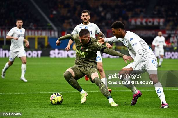 Milan's Croatian forward Ante Rebic fights for the ball with Empoli's Belgian defender Koni de Winter during the Italian Serie A football match...