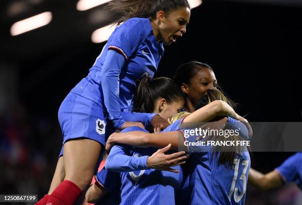 France's forward Eugenie Le Sommer is congratuled by teammates after scoring a goal during the women's international friendly football match between...