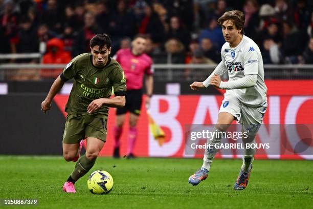 Milan's Spanish midfielder Brahim Diaz fights for the ball with Empoli's Italian midfielder Jacopo Fazzini during the Italian Serie A football match...