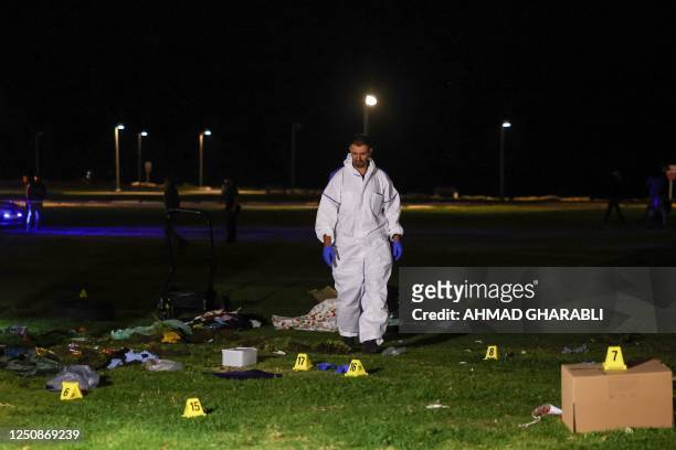 An Israeli policeman inspects the site of an attack in Tel Aviv on April 7, 2023. - One man was killed and four people were wounded in an attack in...