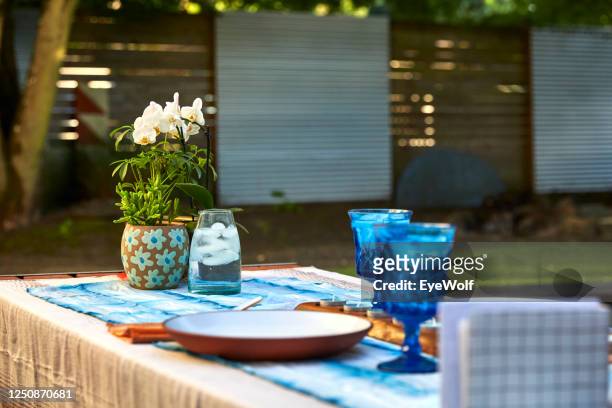 low angle shot of a table setup for a formal dinner in a back yard at sunset. - formal dining stock pictures, royalty-free photos & images