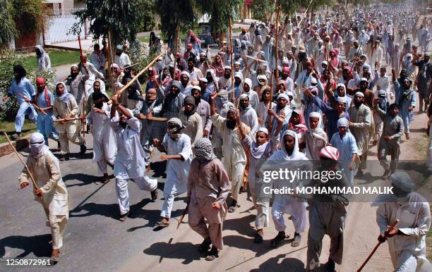 Hundreds of Pakistani Islamic students hold bamboo sticks and shout anti-government slogans against an army raid on the Red Mosque in Islamabad,...