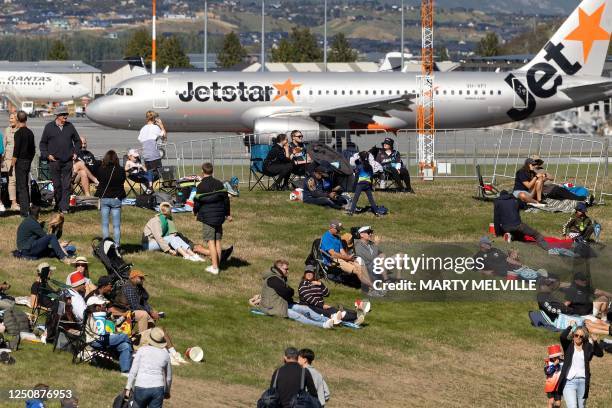 Jetstar passenger aircraft takes off from the nearby Queenstown airport as spectators gather for the third Twenty20 cricket match between New Zealand...