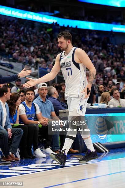Luka Doncic of the Dallas Mavericks high fives coaches during the game against the Chicago Bulls on April 7, 2023 at the American Airlines Center in...
