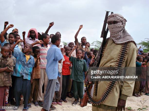 Somali boys chant as they watch hard-line Islamist fighters from Al-Shabab parade during a rally in the streets of Mogadishu on October 30, 2009. The...