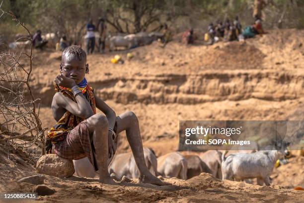 Kid from the Turkana tribe waiting for his family fetching water from a well Climate change in East Africa is causing the worst drought in its...