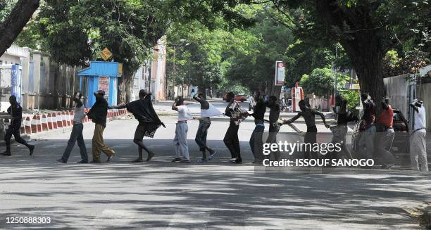 Picture taken on February 27, 2011 shows men suspected of being rebels as they are ledt to a police station flanked by soldiers of Ivory Coast's...