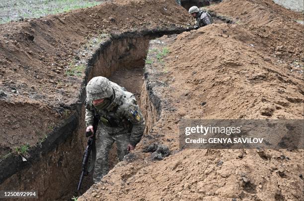 Ukrainian servicemen walks along trenches near the town of Bakhmut, Donetsk region on April 8 amid the Russian invasion of Ukraine. - Bakhmut has...